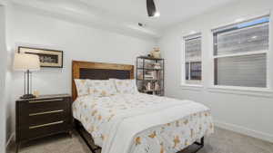 Bedroom featuring a wood-panel headboard, recessed lighting, and a ceiling fan