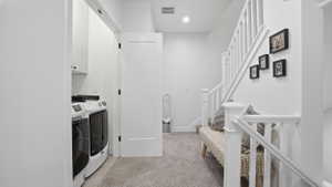 Dedicated laundry area featuring white cabinetry