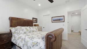 Carpeted bedroom featuring white walls, recessed lighting, and a ceiling fan