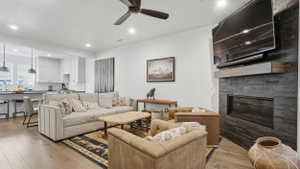 Open-concept living space featuring wood-finish flooring, a contemporary ceiling fan, and recessed lighting