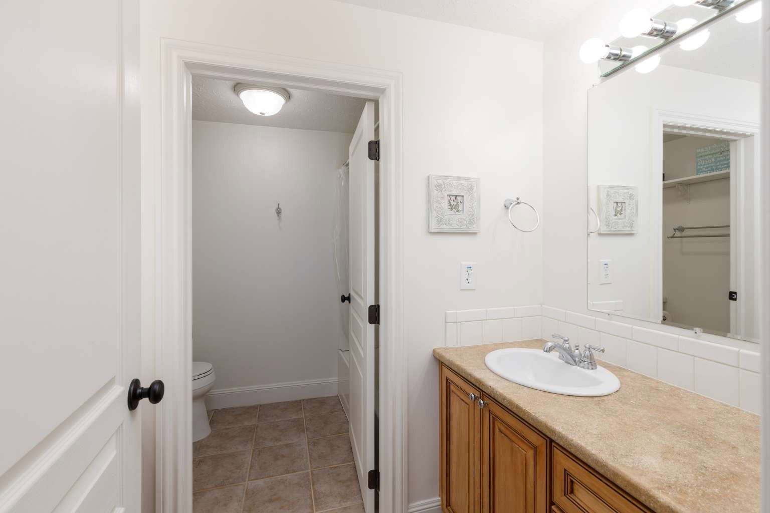 Bathroom featuring a single vanity with wood cabinetry and a neutral countertop