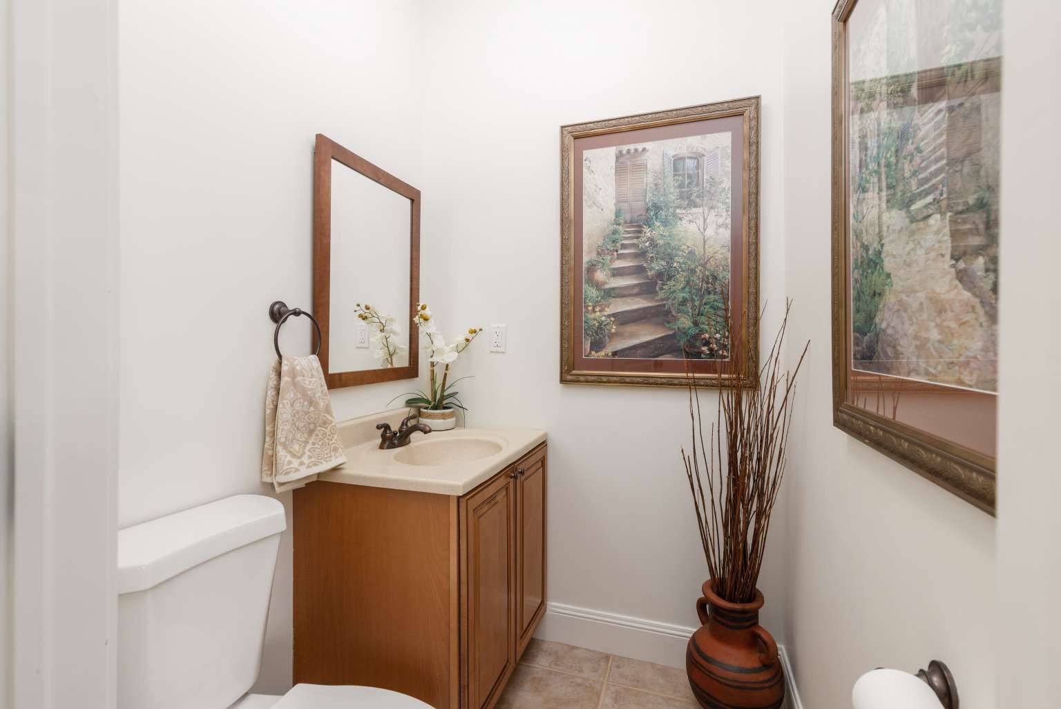 Powder room featuring a wood-finish vanity with an integrated sink, a dark bronze faucet, and a coordinating framed mirror