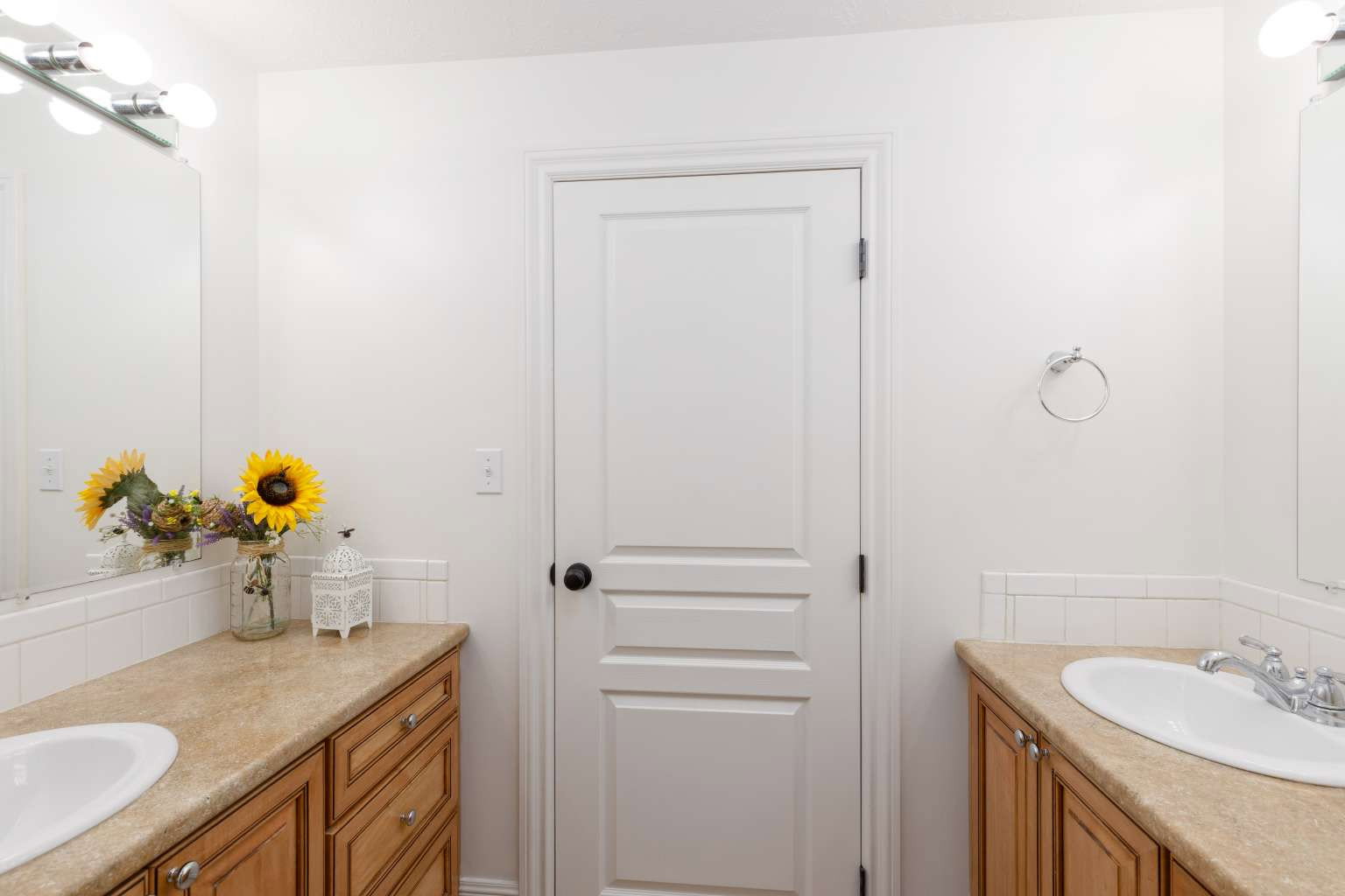 Dual vanity featuring wood-finish cabinetry and light-toned countertops