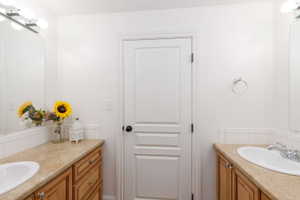 Dual vanity featuring wood-finish cabinetry and light-toned countertops