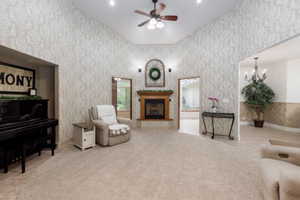 Spacious living area featuring a vaulted ceiling and decorative wallpaper