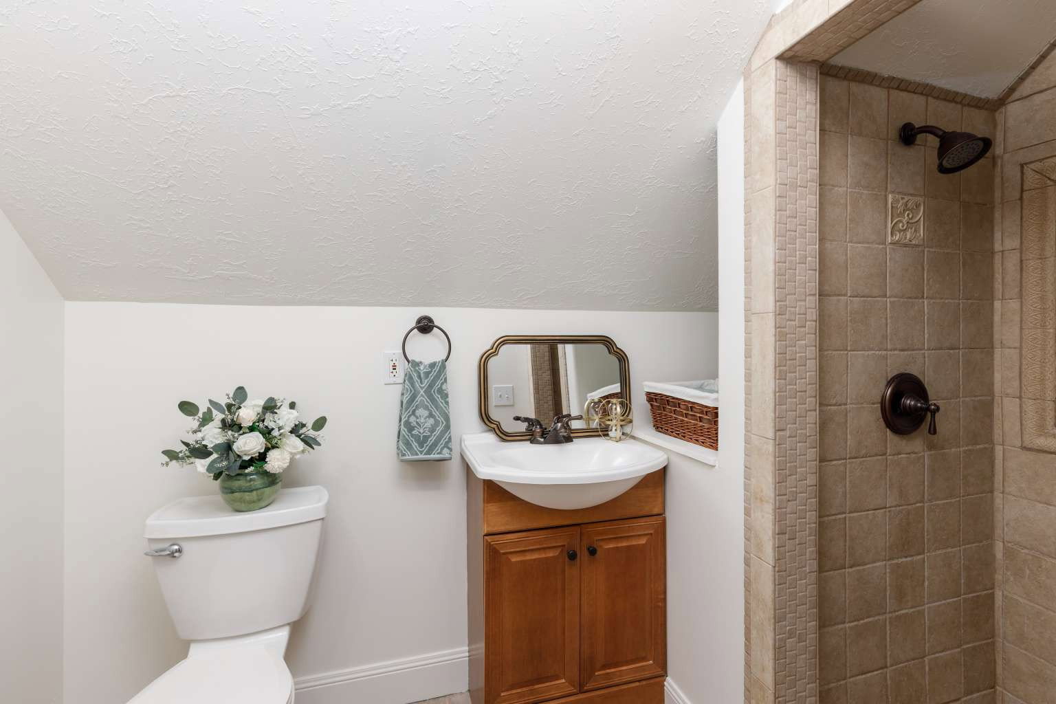 Bathroom featuring a shower with tan square tiles and decorative accents