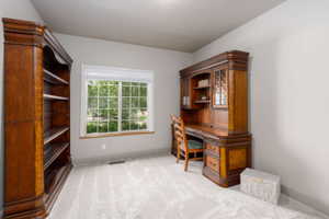 Room featuring light gray wall paint, light-toned carpet flooring, and a large window with white grid panes