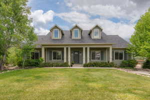 Sage green siding exterior with a covered front porch supported by four columns