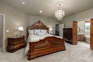 Spacious bedroom featuring neutral textured walls and light-colored carpet flooring