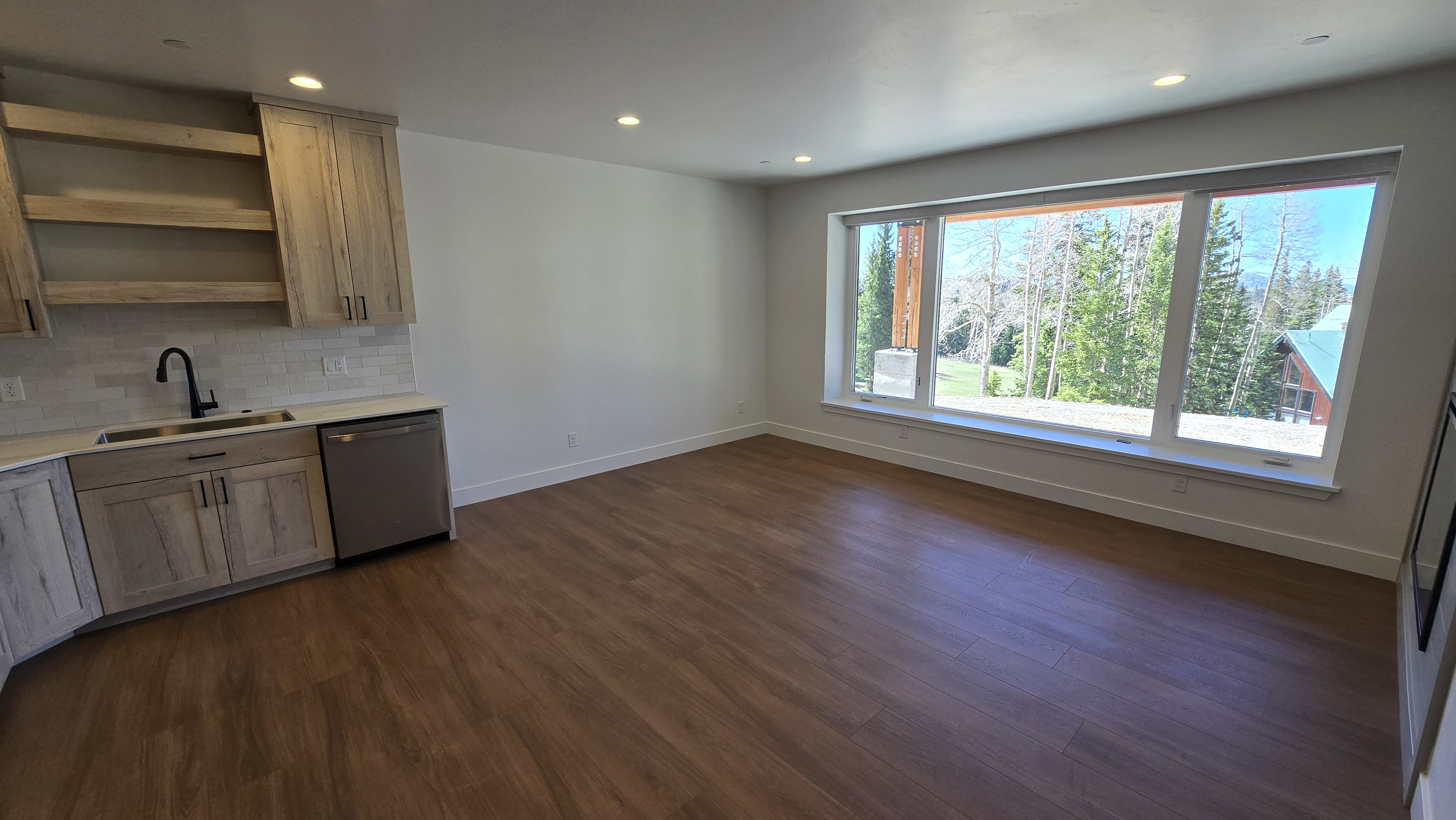 Expansive window offering a mountain and tree-lined backdrop