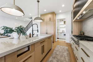 Contemporary kitchen featuring a large island with an undermount sink and a matte black faucet