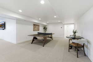 Spacious lower level featuring recessed lighting, a neutral carpeted floor, white walls, and a built-in entertainment area
