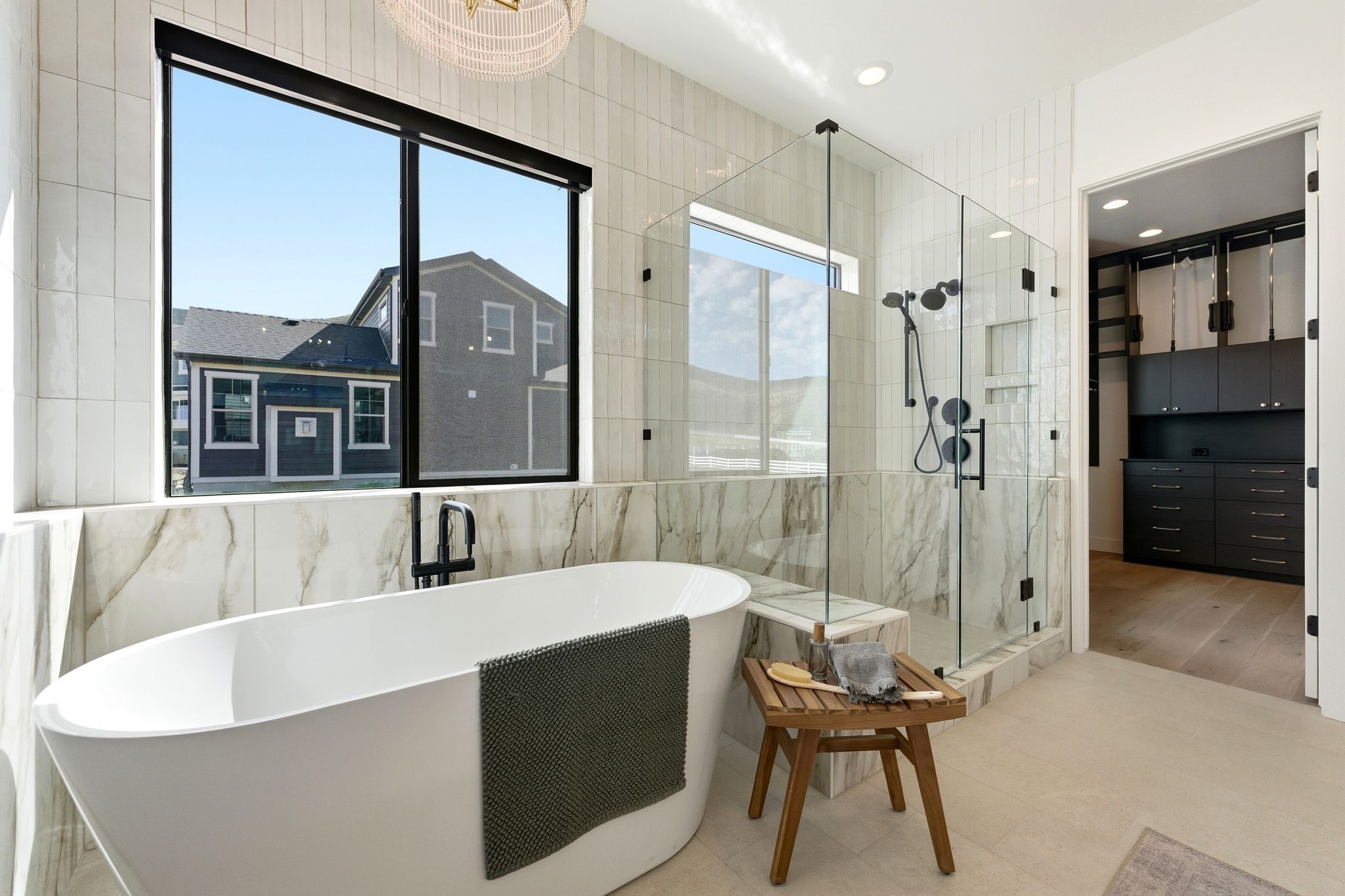 Freestanding soaking tub with a floor-mounted matte black faucet