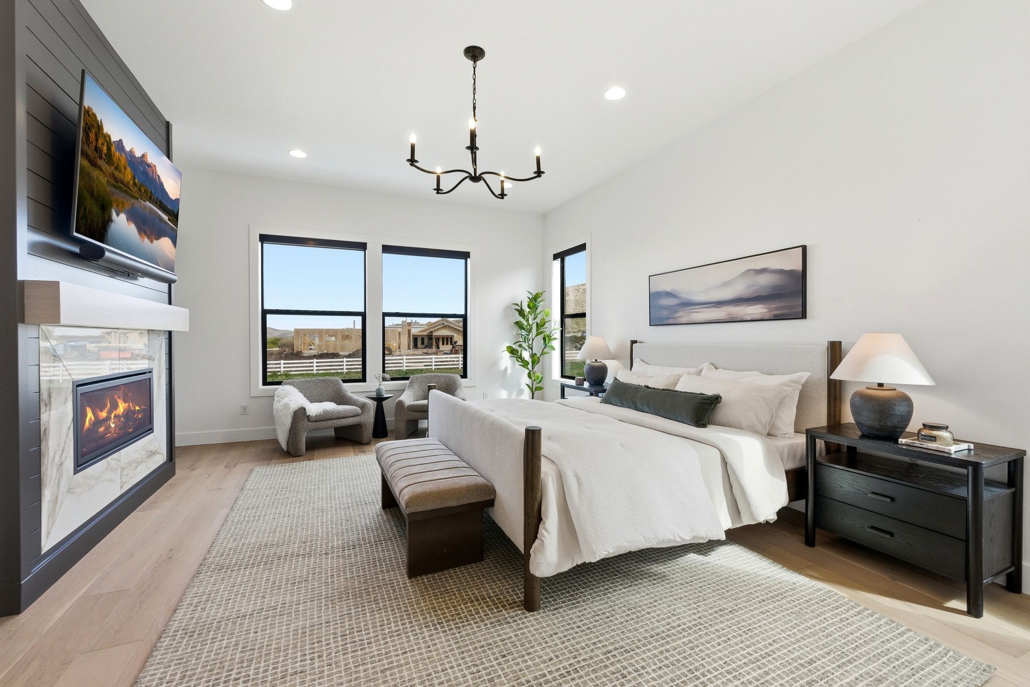 Bedroom featuring a built-in fireplace with a tiled surround, wood-finish flooring, a contemporary chandelier, recessed lighting, and multiple windows