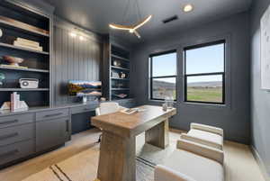 Dedicated office space featuring custom built-in shelving, integrated desk, and storage cabinetry
