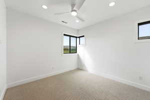 Bright room featuring a ceiling fan, recessed lighting, and expansive windows