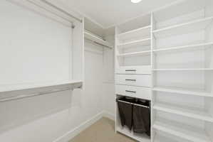 Custom closet system featuring multiple hanging rods, adjustable shelving, and integrated drawers with contemporary hardware