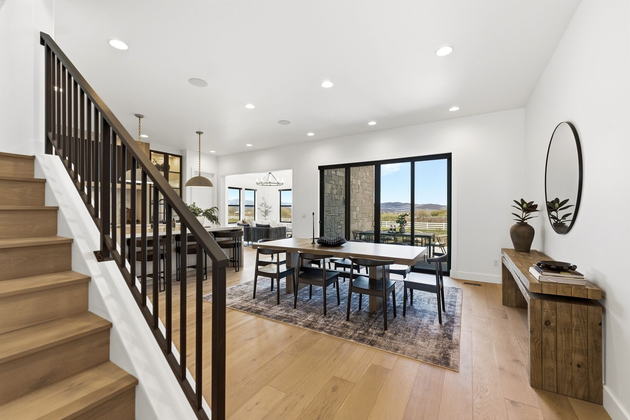 Wood-finish flooring throughout, featuring a staircase with dark wood balusters and handrail