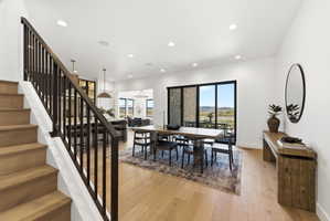 Wood-finish flooring throughout, featuring a staircase with dark wood balusters and handrail