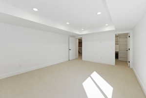 Spacious room with light-toned carpeting and white walls