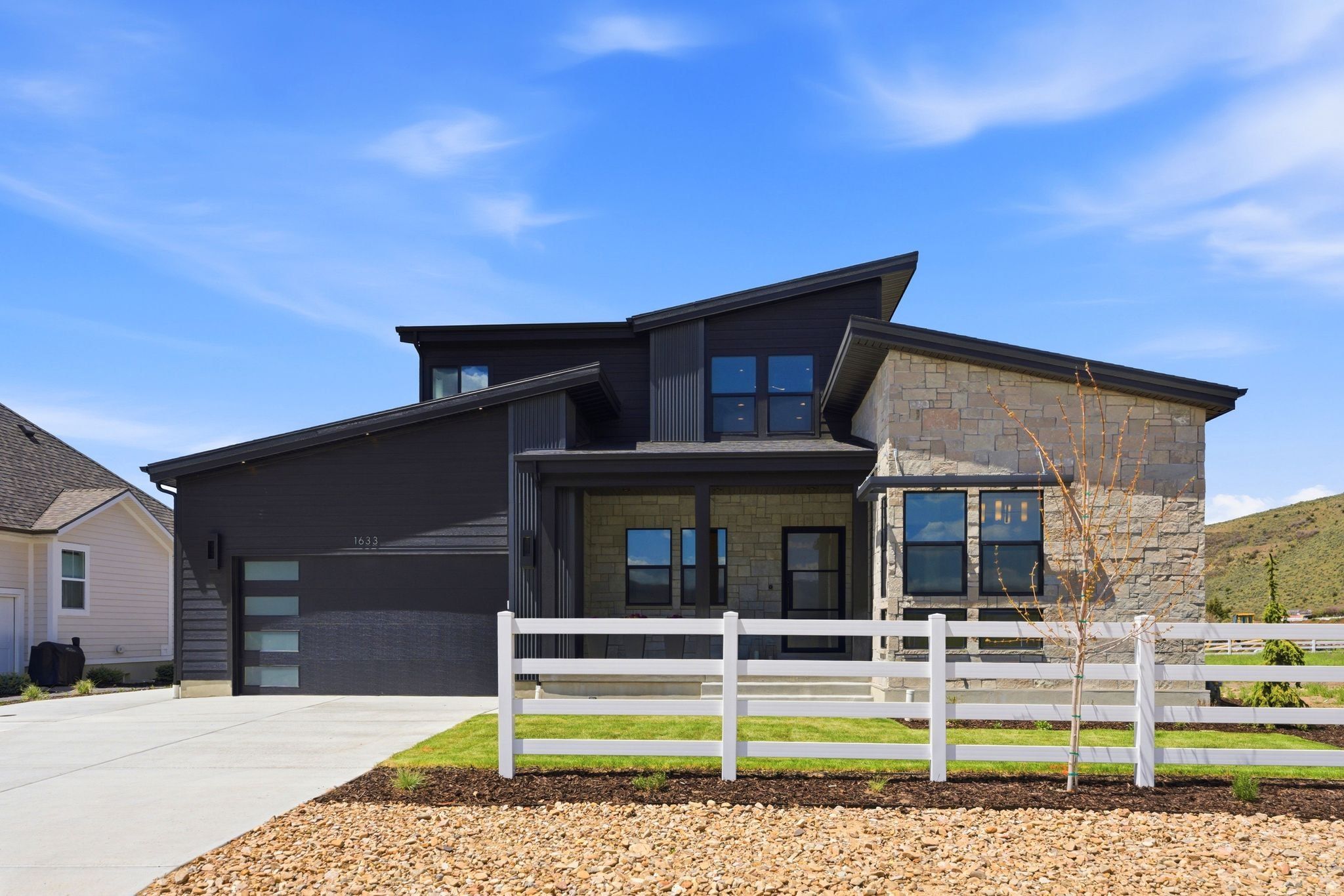 Contemporary exterior featuring dark horizontal siding and stone accents