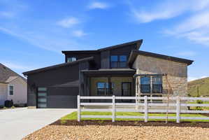 Contemporary exterior featuring dark horizontal siding and stone accents