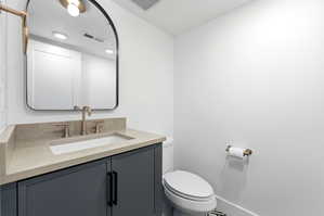 Contemporary vanity with a rectangular undermount sink, light-toned countertop, and gold-finish faucet