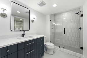 Contemporary bathroom featuring a dark blue vanity with a white countertop, an undermount sink, and a black framed mirror