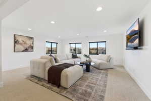 Spacious room featuring neutral carpet flooring, recessed lighting, and multiple windows with exterior rock formations
