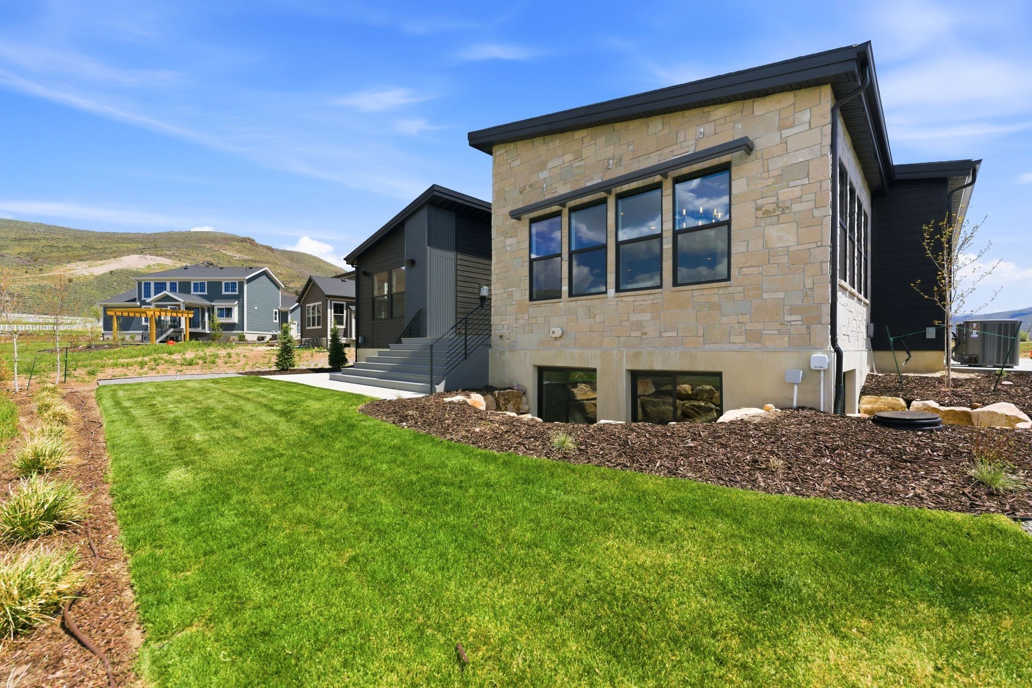 Modern exterior featuring stone veneer and dark siding