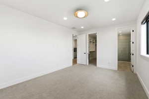 Carpeted room with white walls, a modern circular ceiling light fixture, recessed lighting, and a dark-framed window