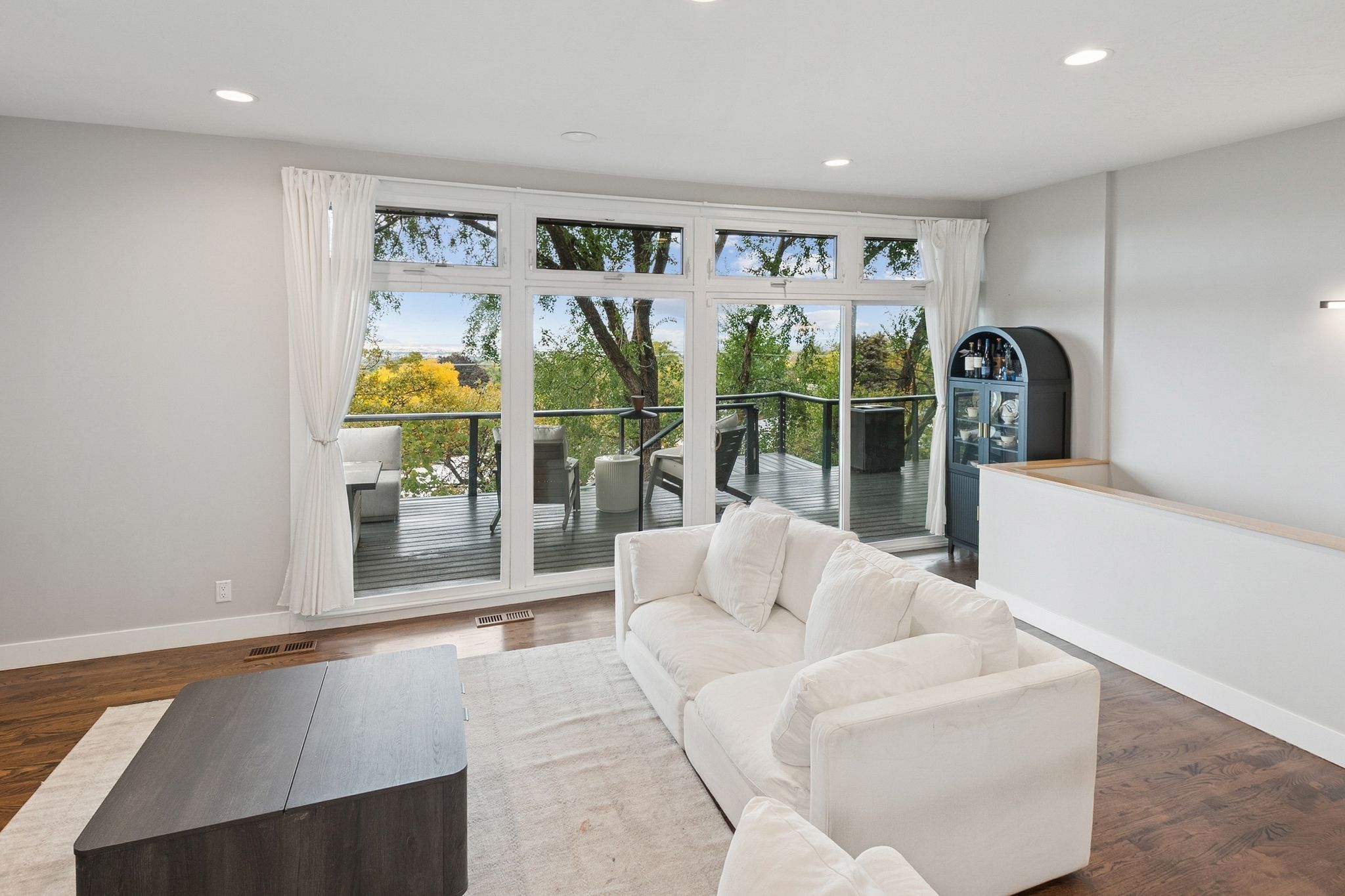 Spacious living area featuring expansive glass doors opening to an outdoor deck