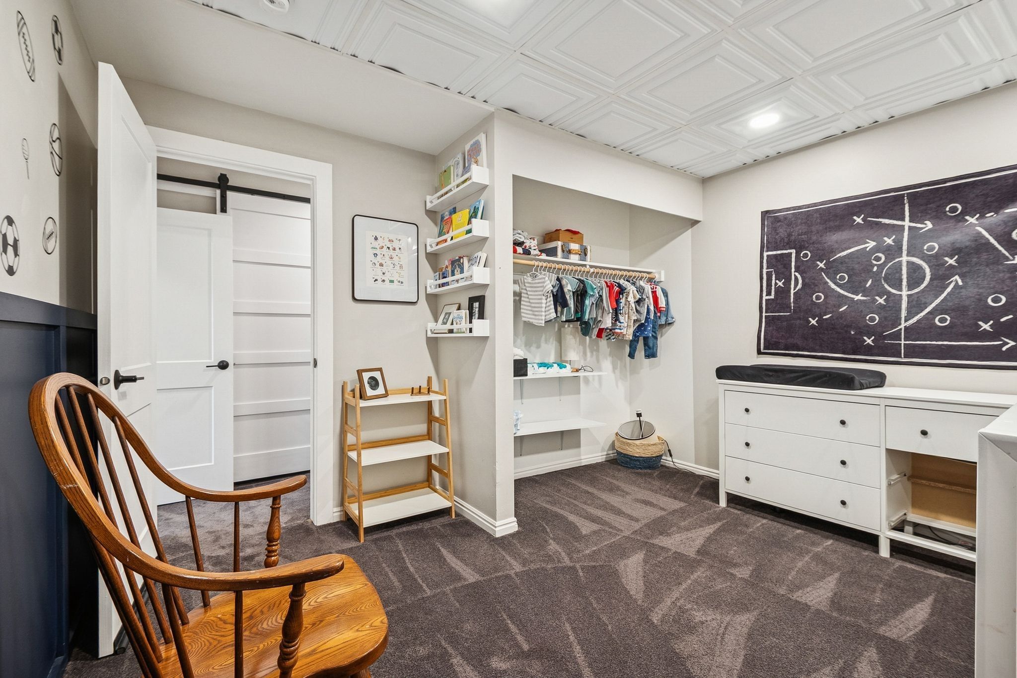 Room featuring a patterned acoustic ceiling, plush carpet, and a custom built-in closet with shelving and hanging space