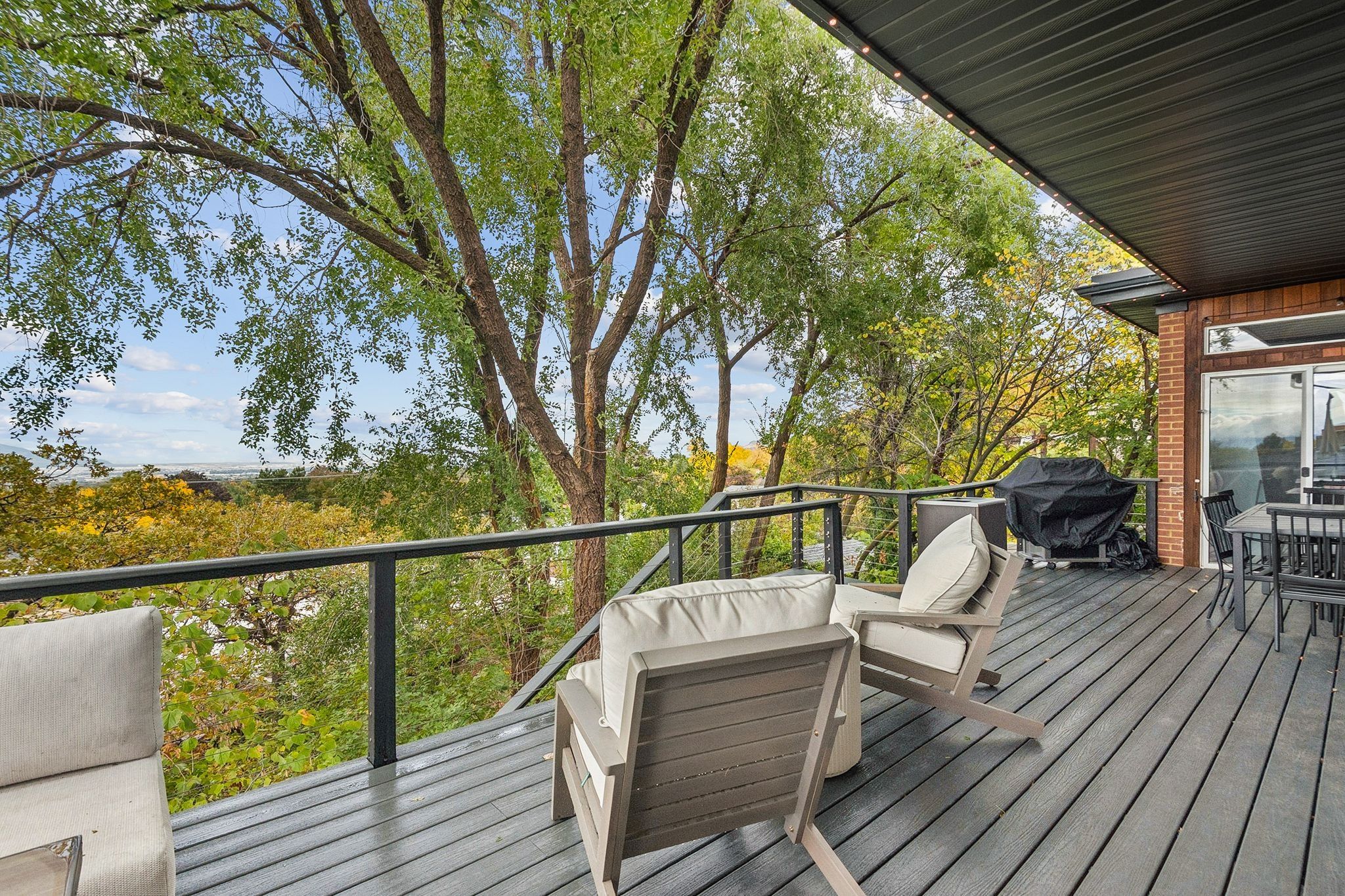 Spacious elevated deck featuring composite decking, black railings, and a dark soffit with integrated lighting