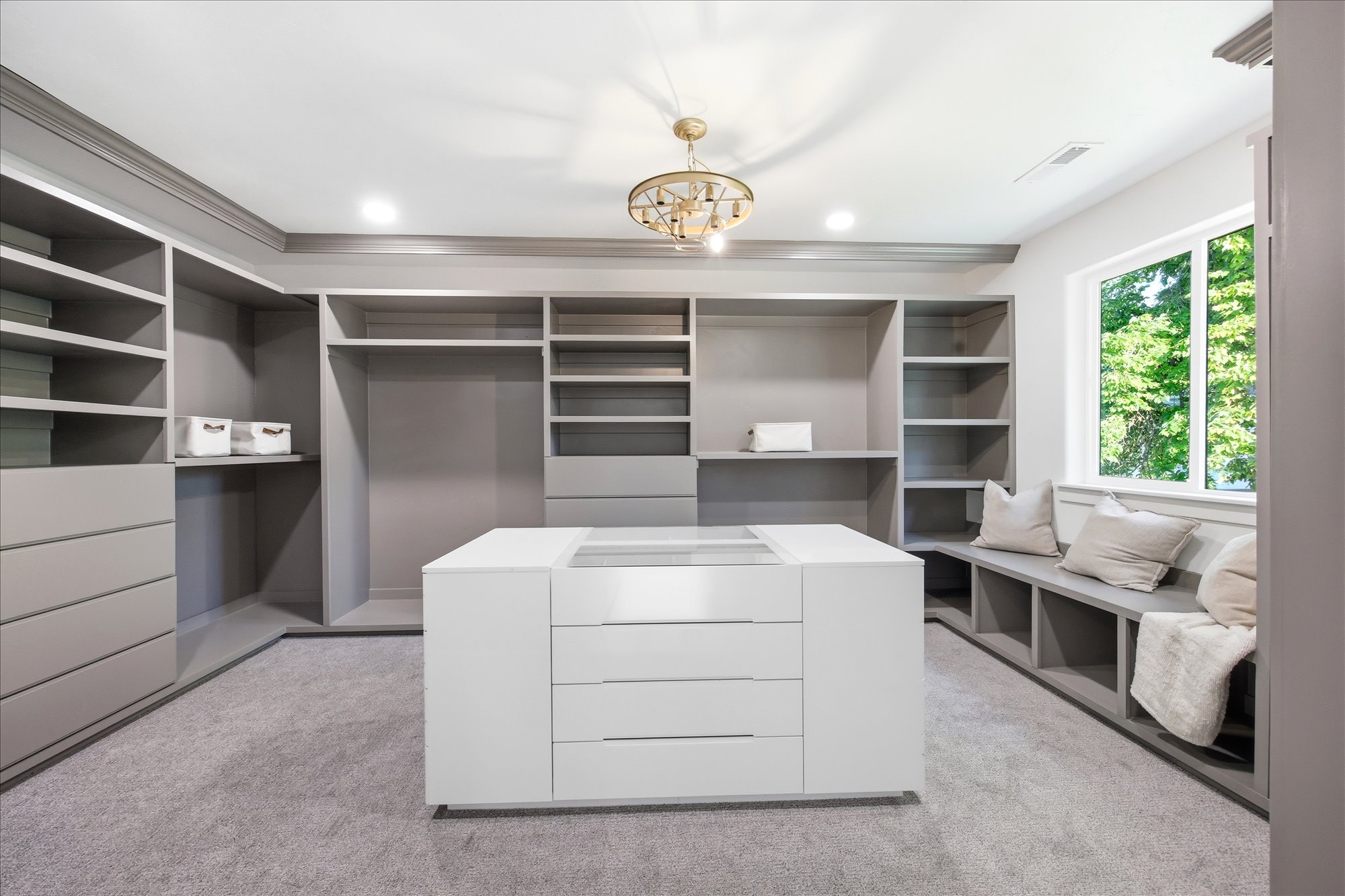 Built-in closet system featuring extensive shelving, hanging space, and drawers in a neutral finish