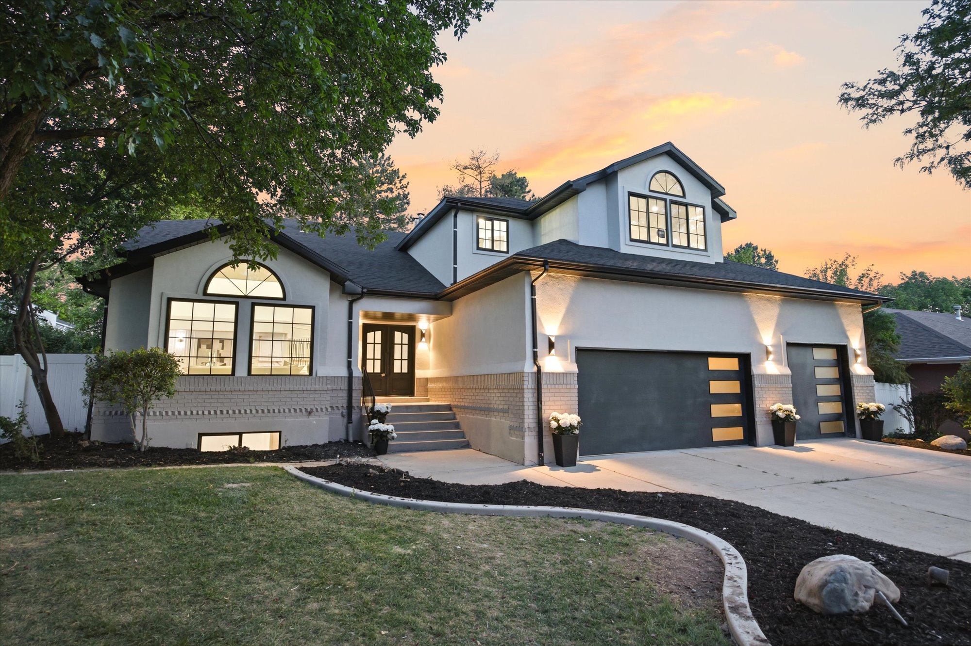 Contemporary two-story residence featuring a dual garage with modern panel doors