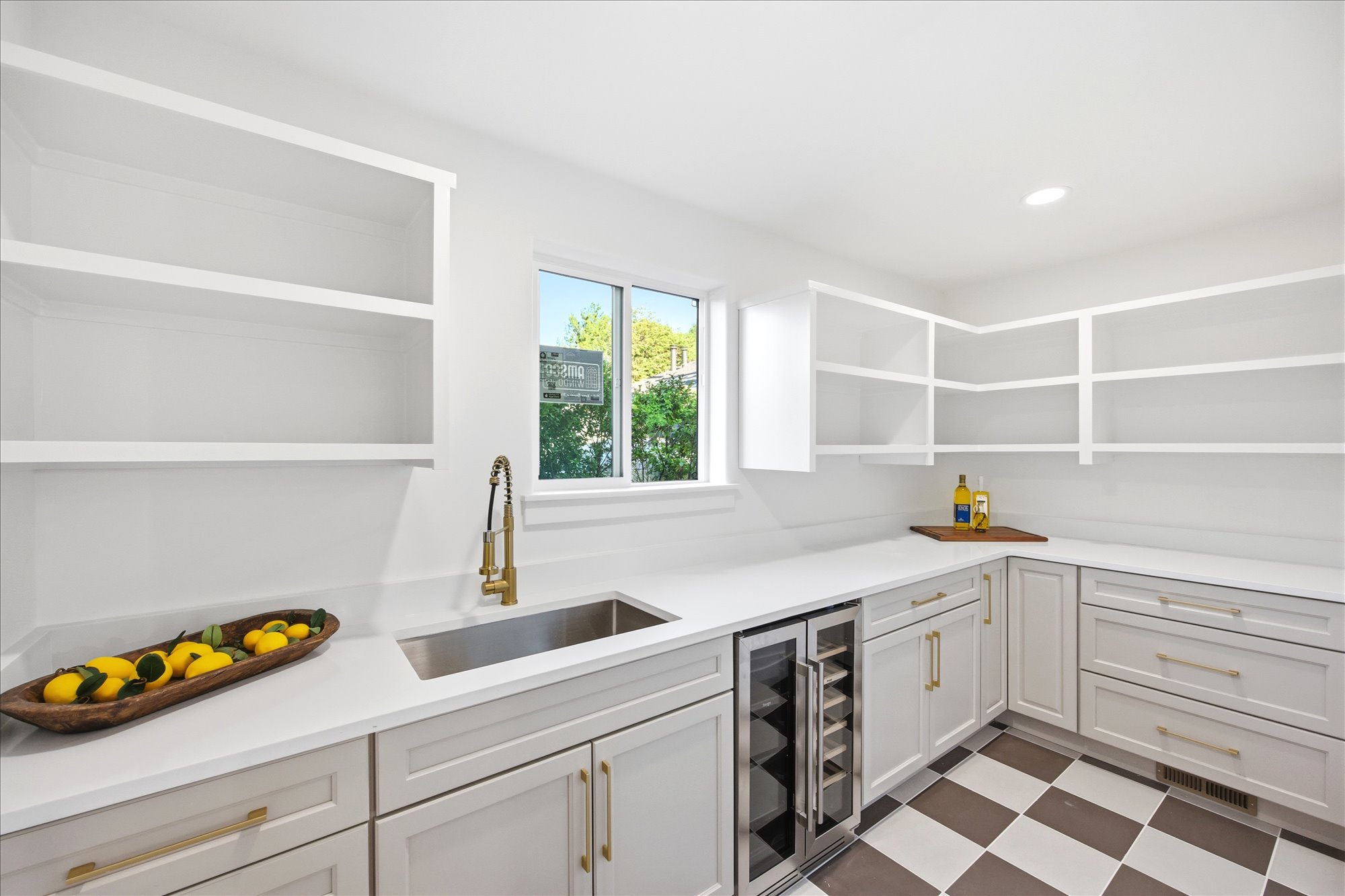 Built-in cabinetry with light-colored shaker-style doors, gold-tone hardware, and white countertops