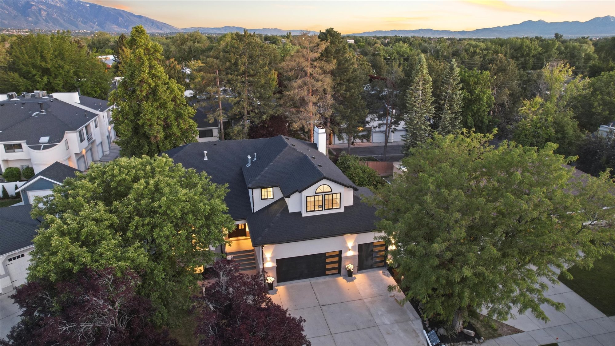 Contemporary two-story residence featuring a dark shingled roof and light-colored siding