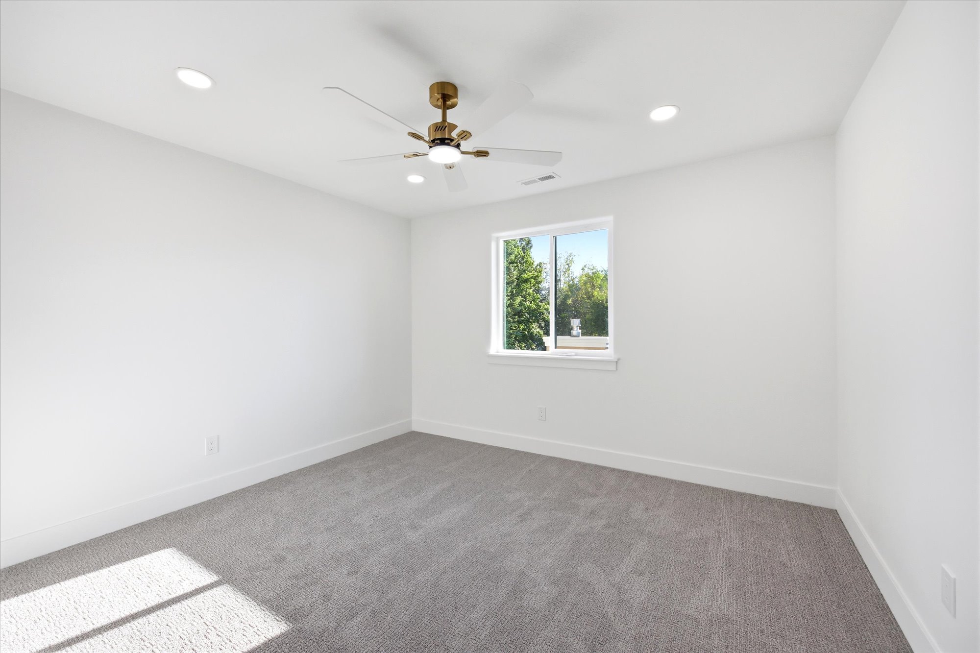 Room featuring a single window, recessed lighting, and a ceiling fan with integrated lighting