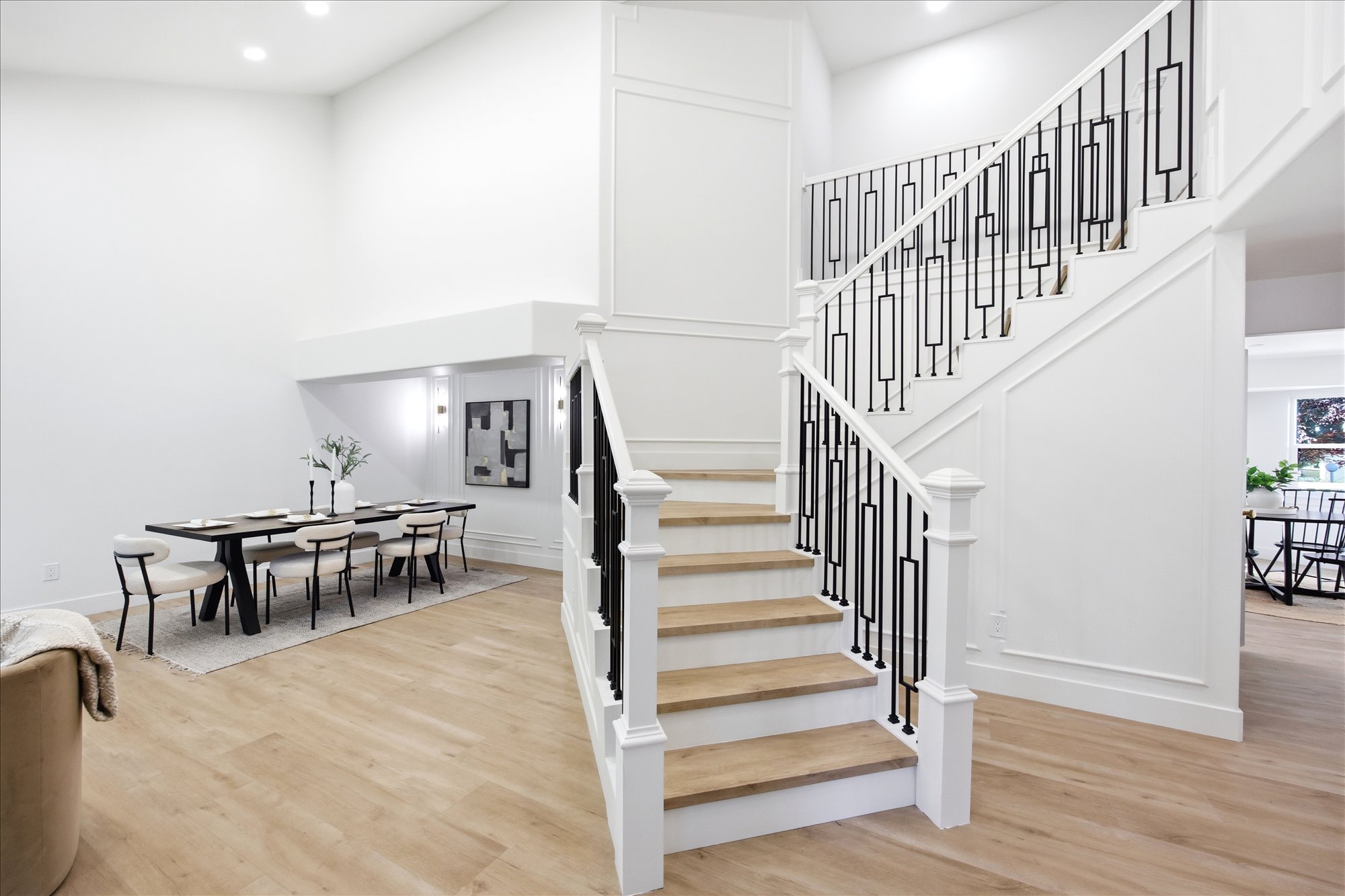 Grand foyer featuring a multi-level staircase with decorative black iron balusters and wood-finish treads