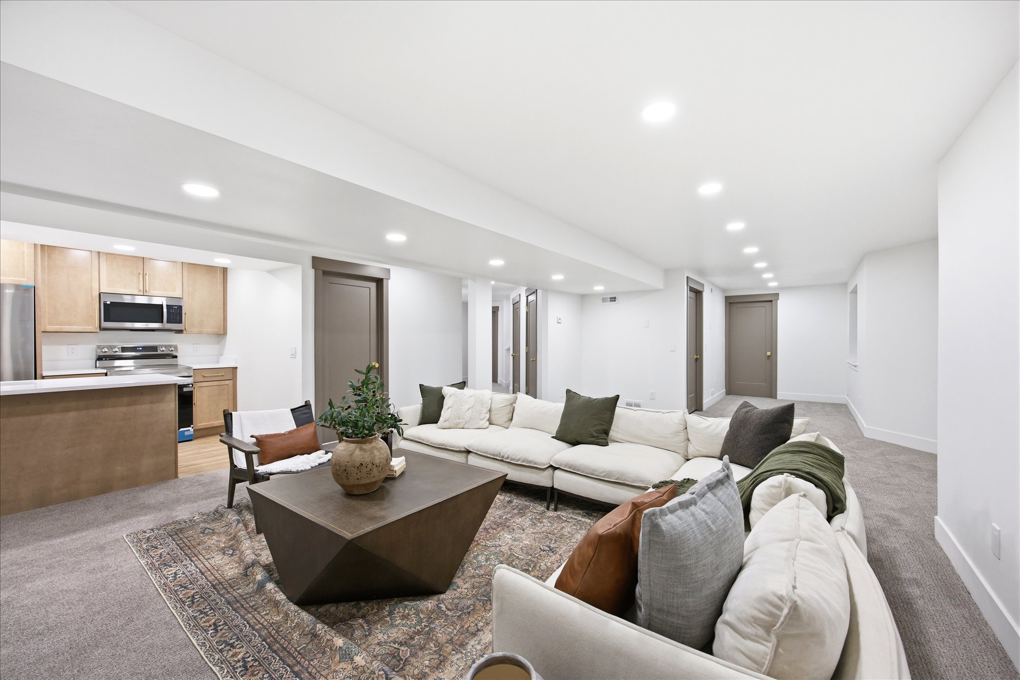 Open-concept living space with recessed lighting, carpet flooring, and a full kitchen