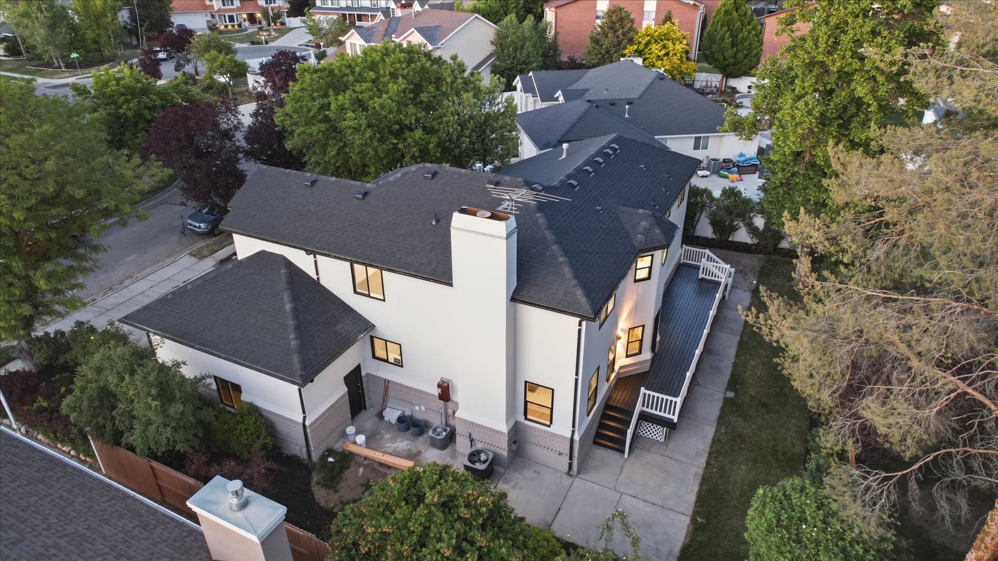 Exterior featuring a dark shingle roof, light-colored siding, a prominent chimney, and a multi-level deck with white railings