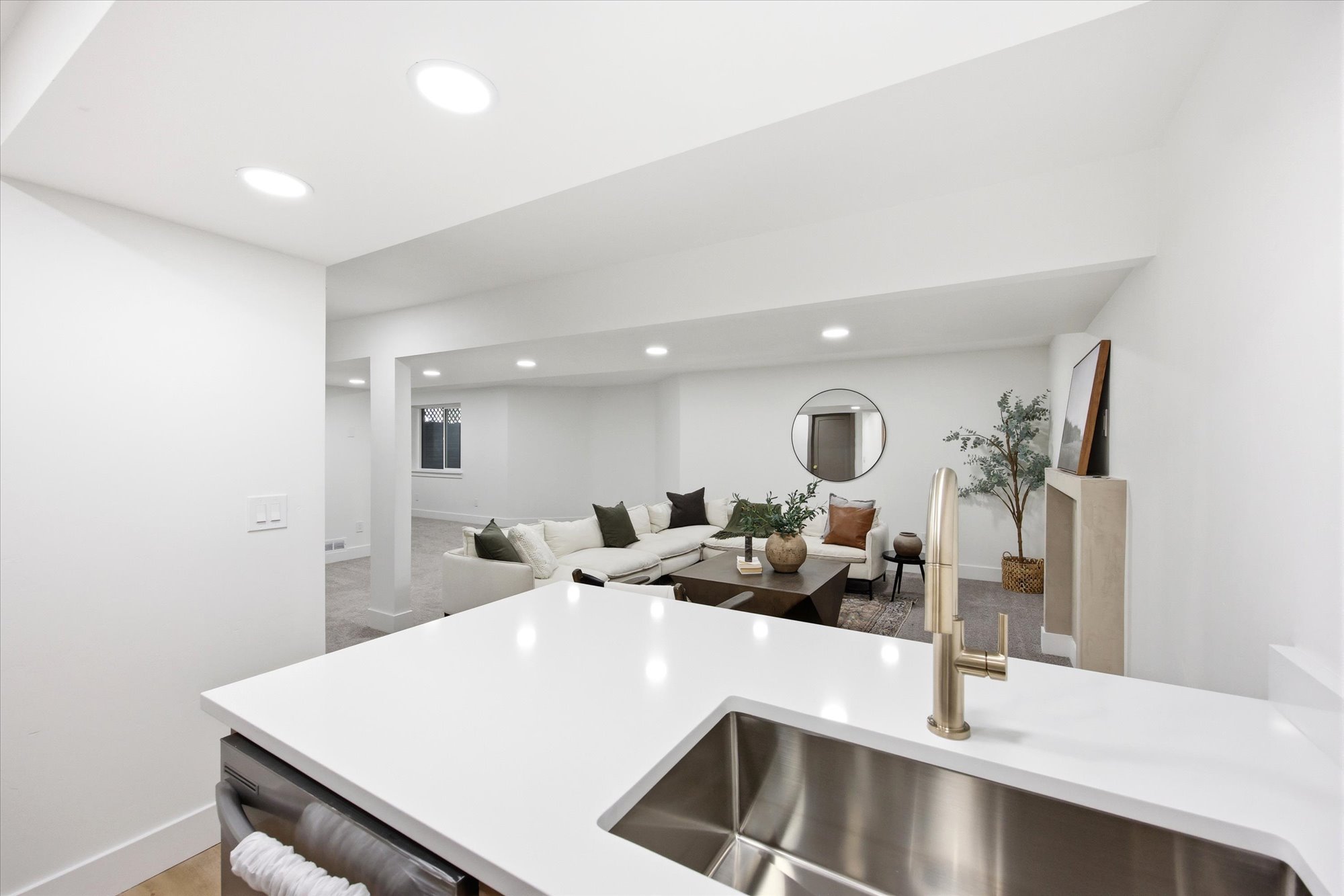 Kitchen island featuring a stainless steel undermount sink and a gold-finish faucet