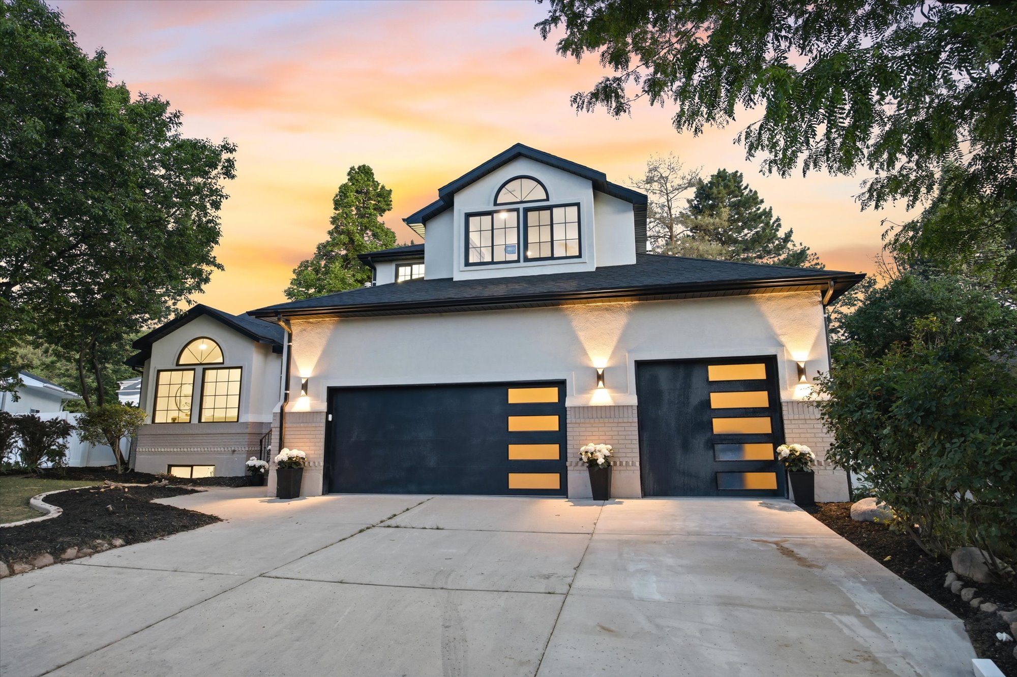 Contemporary residence featuring a light-colored exterior with dark trim accents and a dark-toned roof