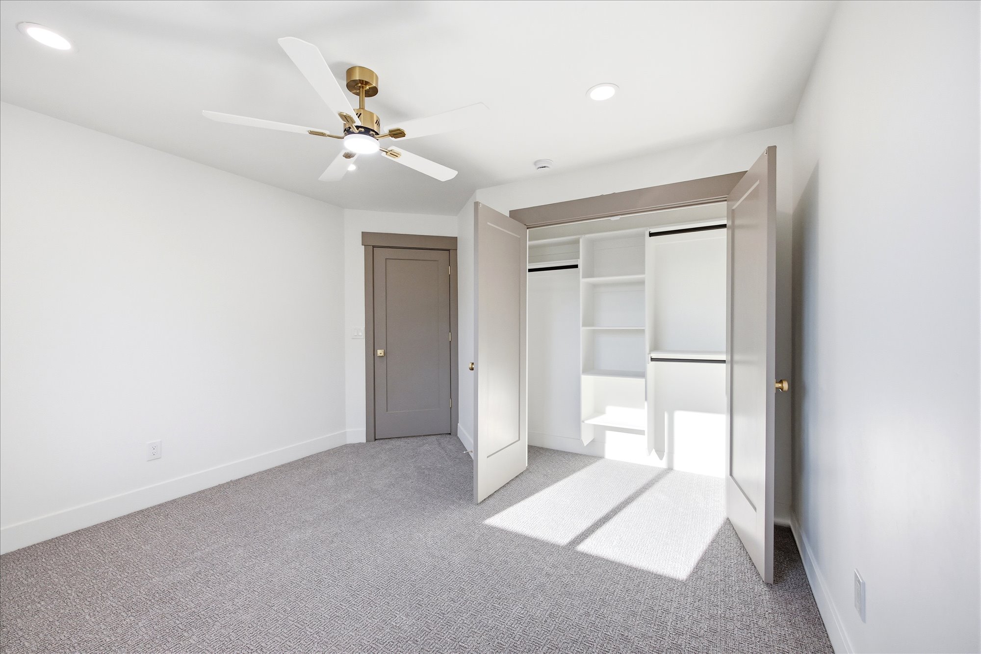 Neutral tone wall paint, recessed lighting, and a gold-finish ceiling fan with lighting fixture