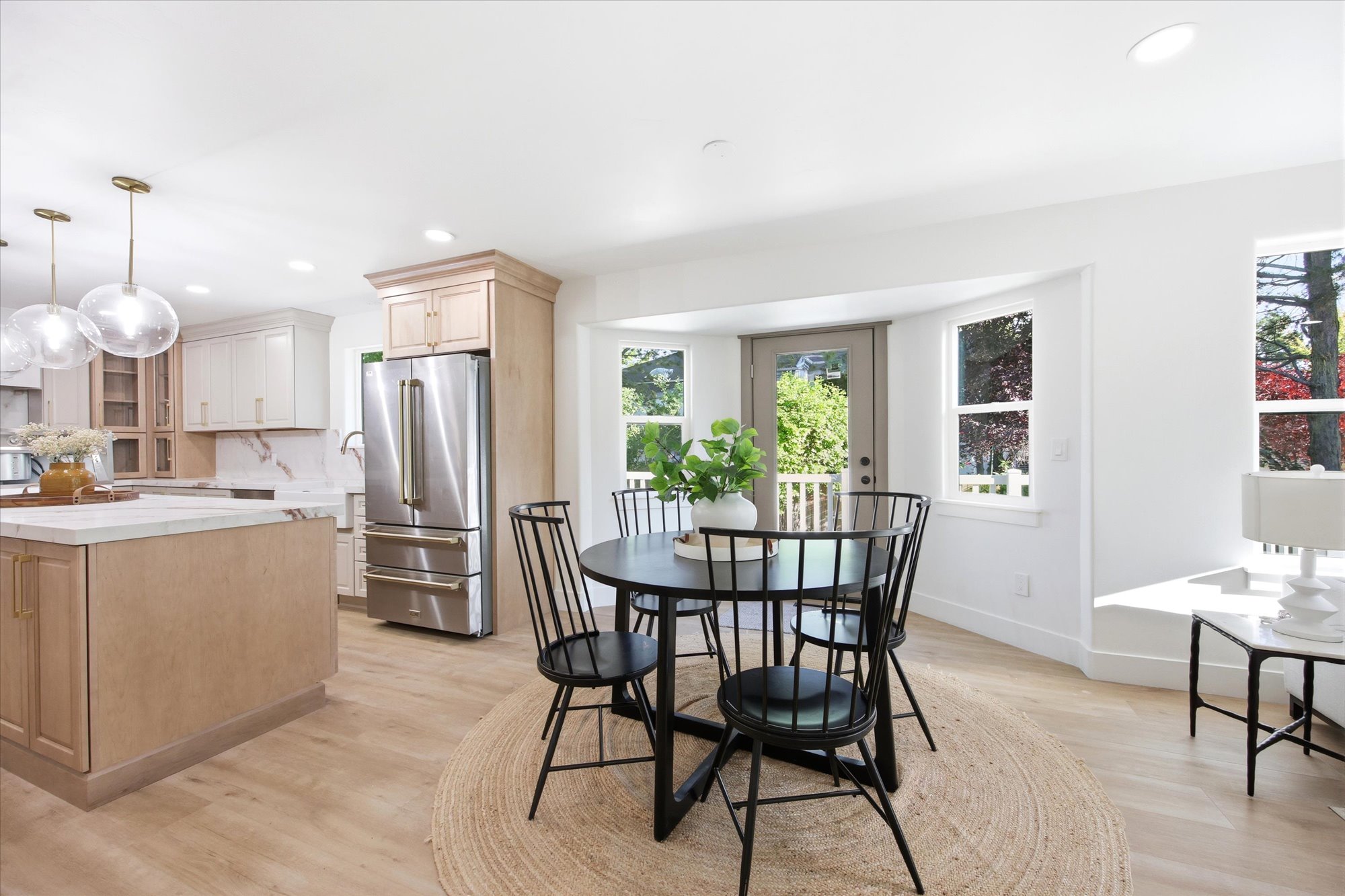 Open-concept kitchen and dining area featuring light wood-finish flooring, recessed lighting, and a kitchen island with a light-toned countertop
