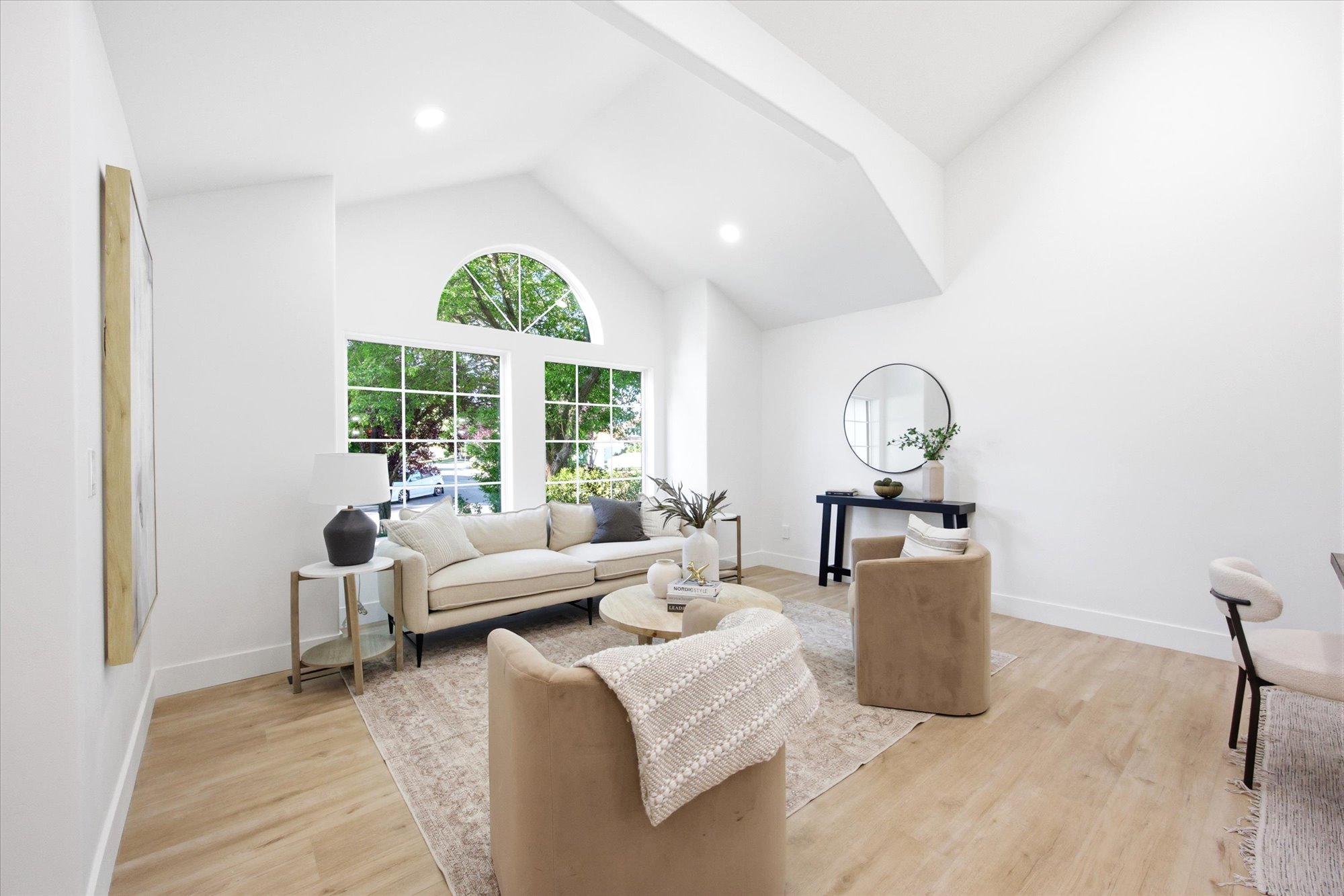 Vaulted ceilings featuring recessed lighting and a large arched window
