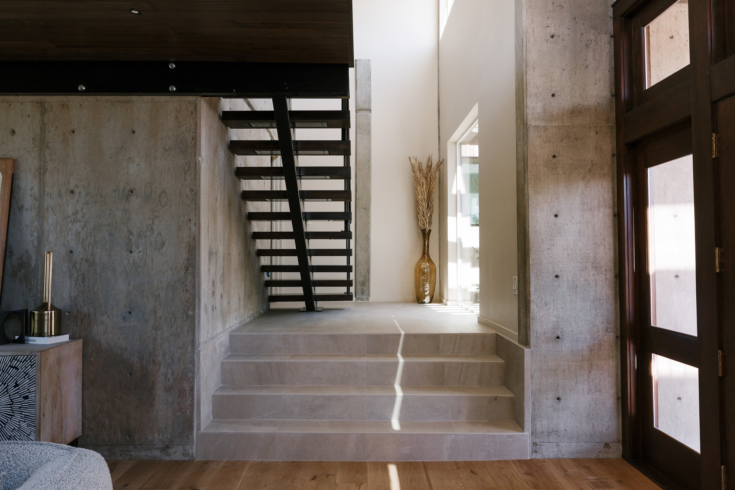 Modern interior featuring wood-finish flooring and concrete walls