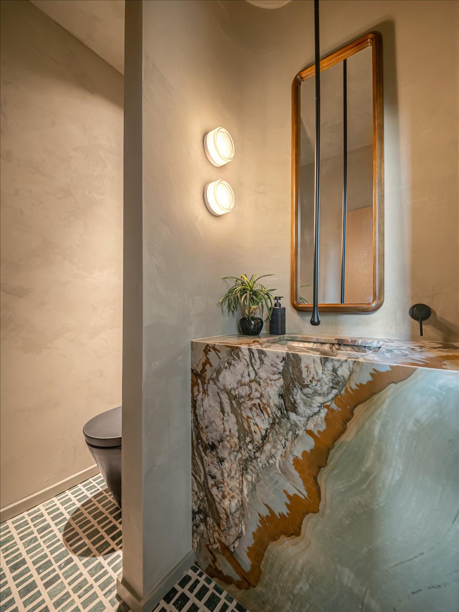 Vanity featuring a live-edge stone countertop with integrated sink and dark-toned wall-mounted faucet