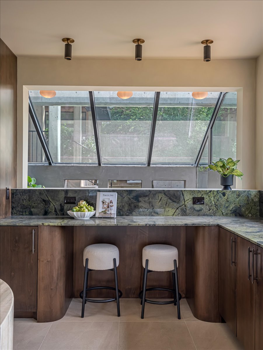 Kitchen island featuring rich wood-finish cabinetry and a striking green-veined countertop